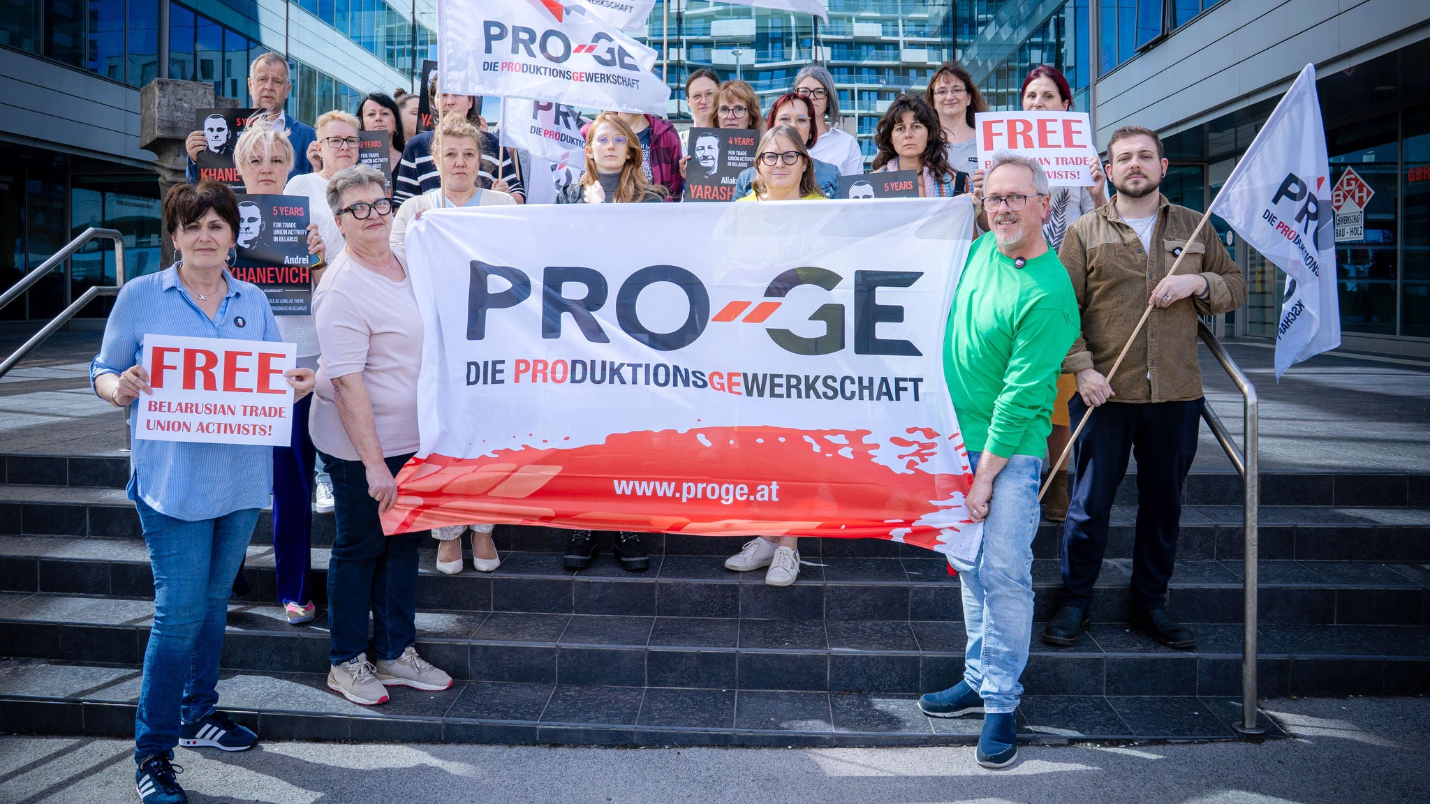 Gruppe mit PRO-GE-Flagge und Schildern "Free Belarusian Trade Union Activists!"