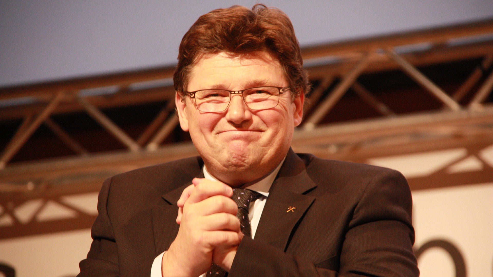 Mann mit dankender Geste und glücklichem Gesichtsausdruck.