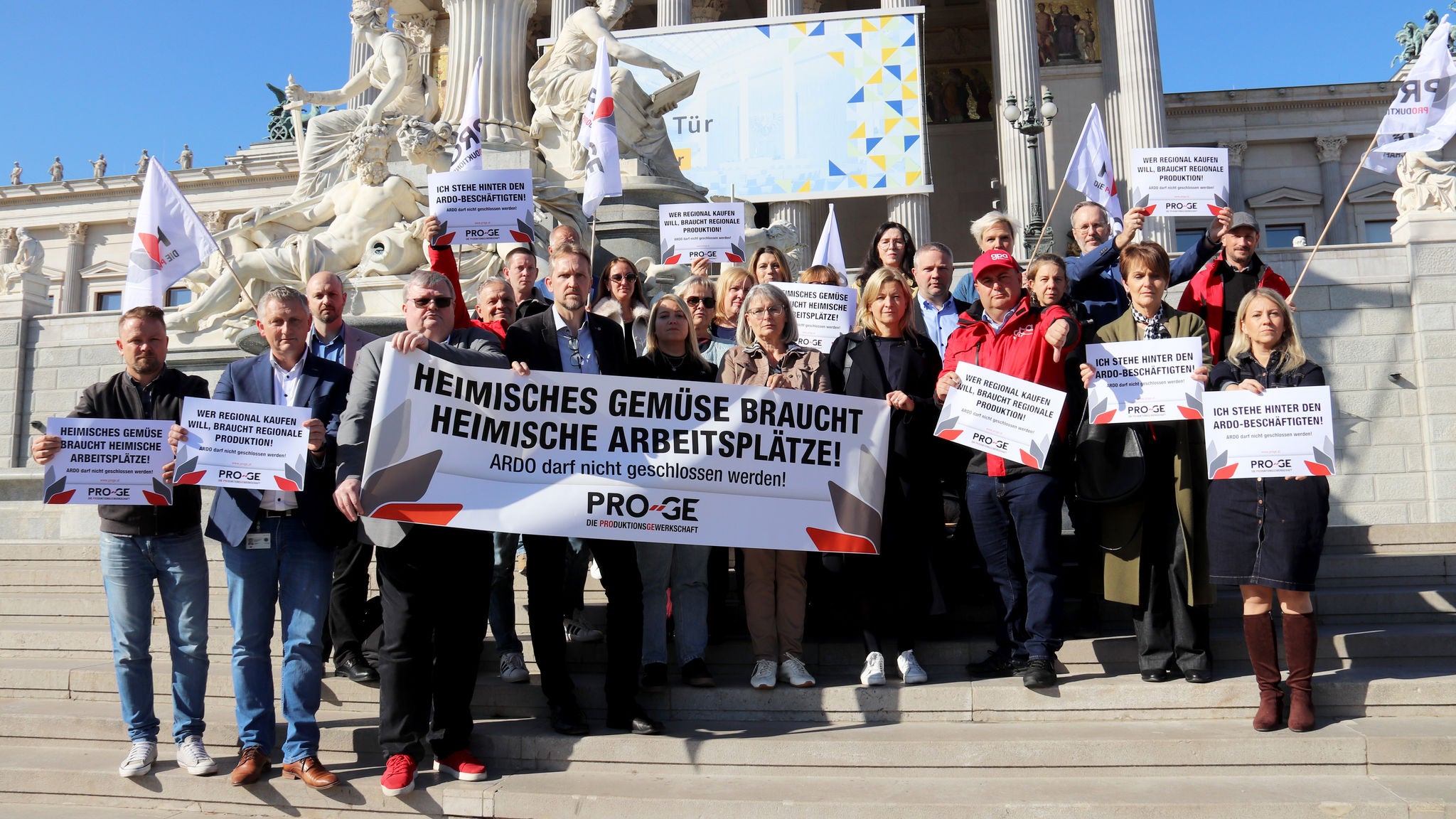 Delegation mit Transparenten "Heimisches Gemüse braucht heimische Arbeitsplätze!" auf den Stufen vor dem Parlament in Wien.