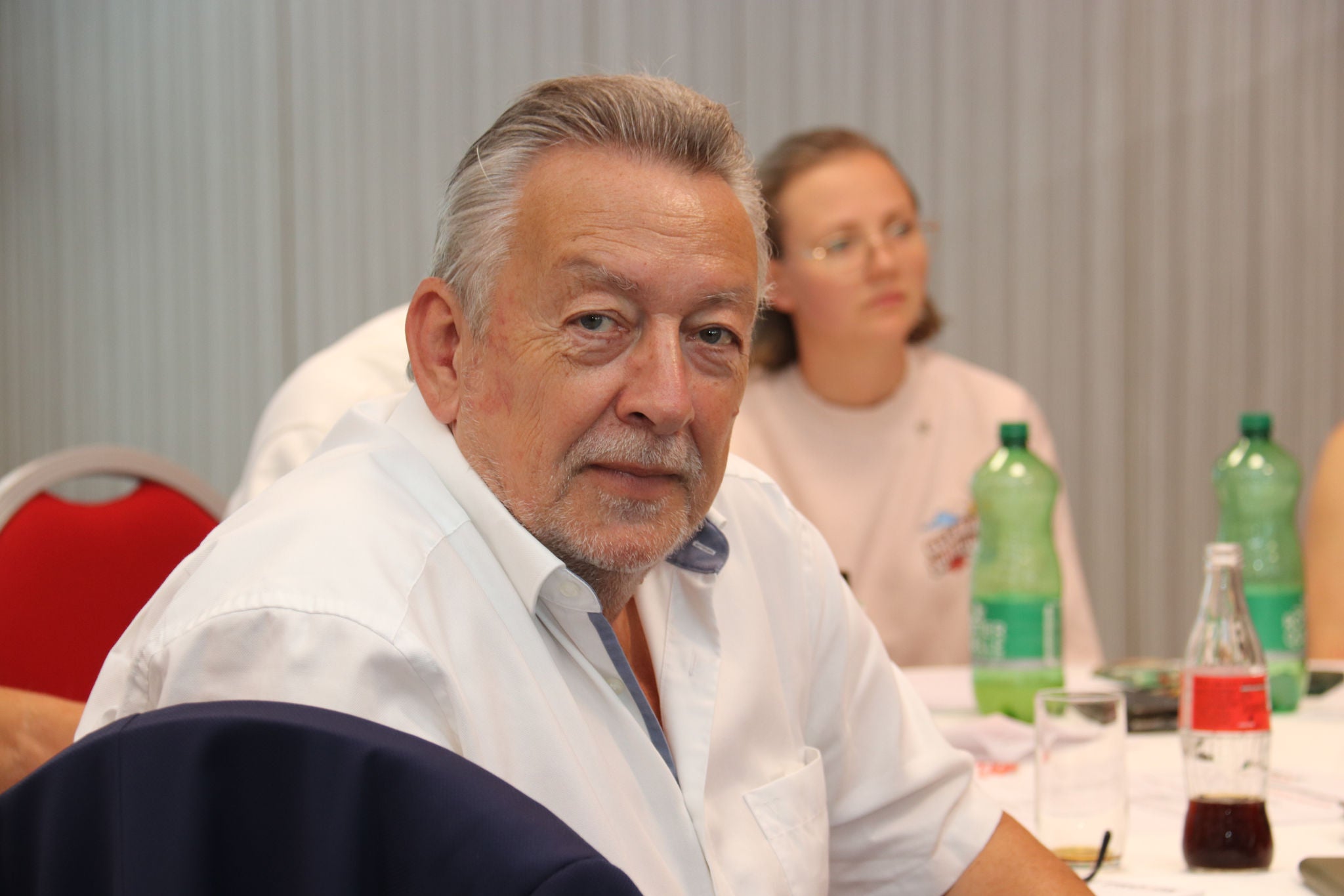 Freundlicher PRO-GE Pensionist am 2. Generationentreffen mit Blick in die Kamera.