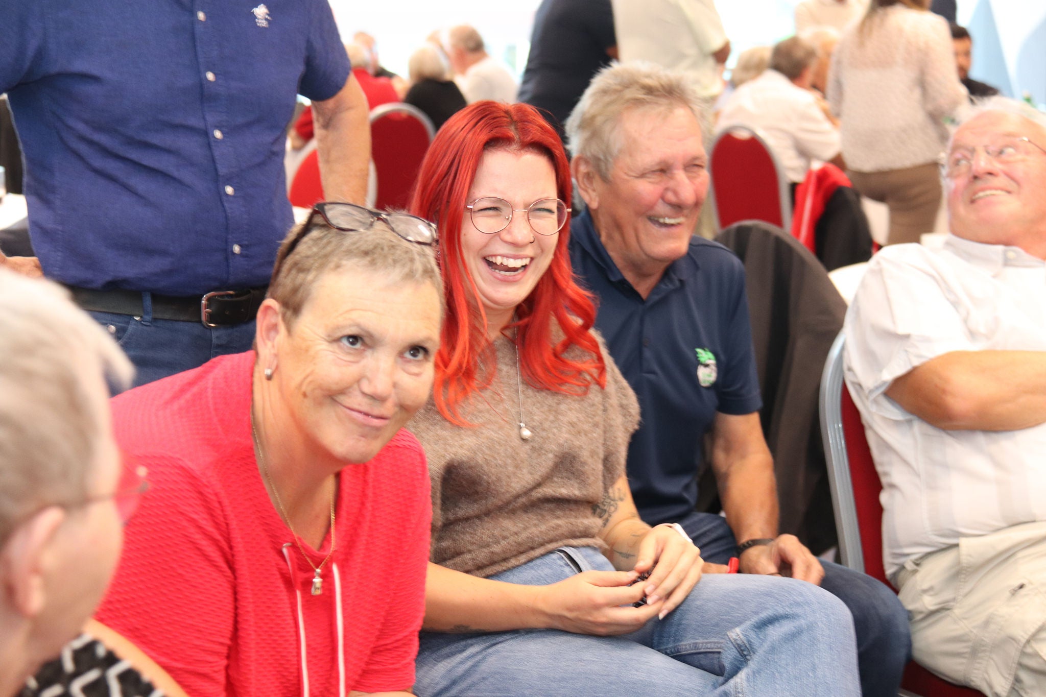 Gesprächssituation Personen unterschiedlichen Alters, offenbar sagte eine der Älteren etwas witziges, da die anderen Teilnehmer:innen lachen.