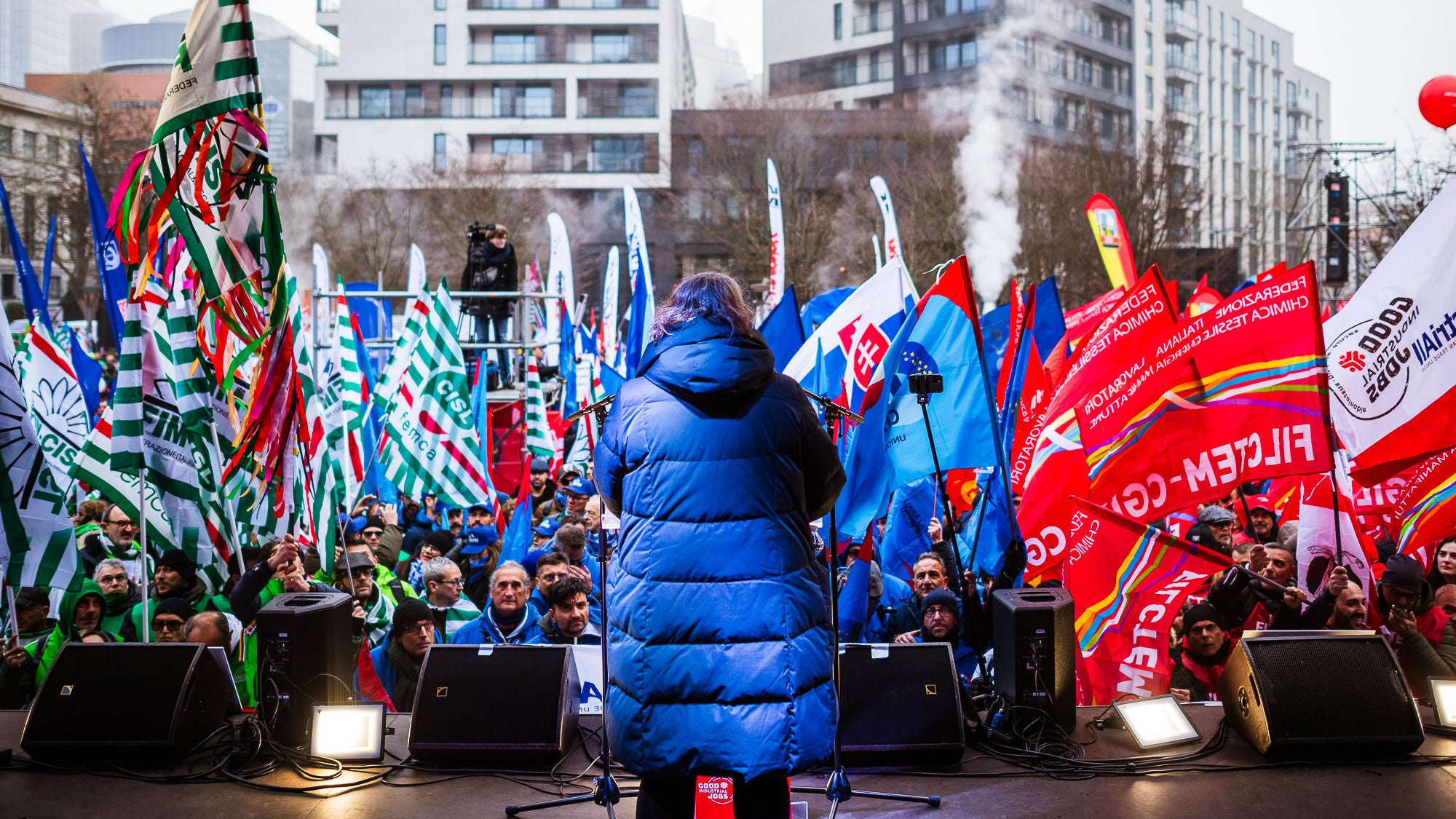 industriAll-Generalsekretärin Kirton-Darling auf der Bühne vor unzähligen Flaggen verschiedener europäischer Gewerkschaften