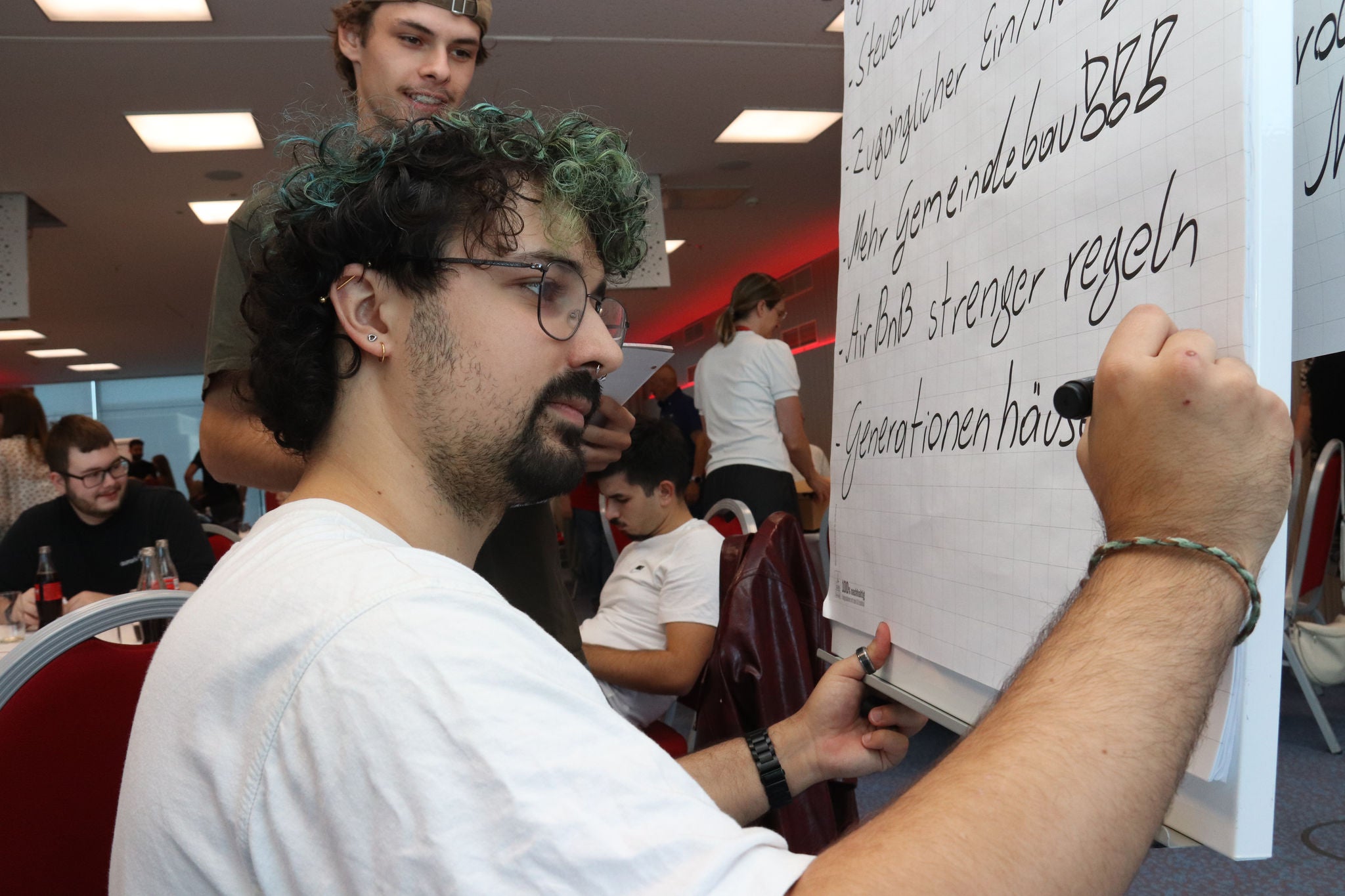 Ein Teilnehmer der PRO-GE Jugend notiert gemeinsame Positionen auf einer Flipchart.