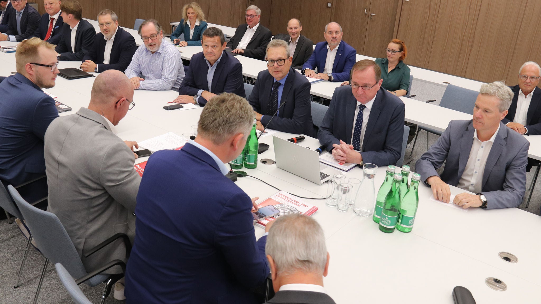 Vertreter der WKÖ und Gewerkschaften sitzen sich an einem langen Tisch gegenüber