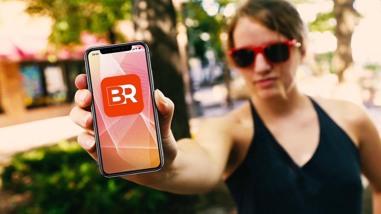 Frau mit Smartphone mit meinBR-App-Logo