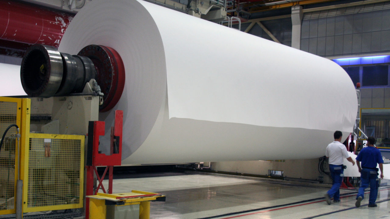 Mehrere Meter hohe und lange Papierrolle in einer Papierfabrik
